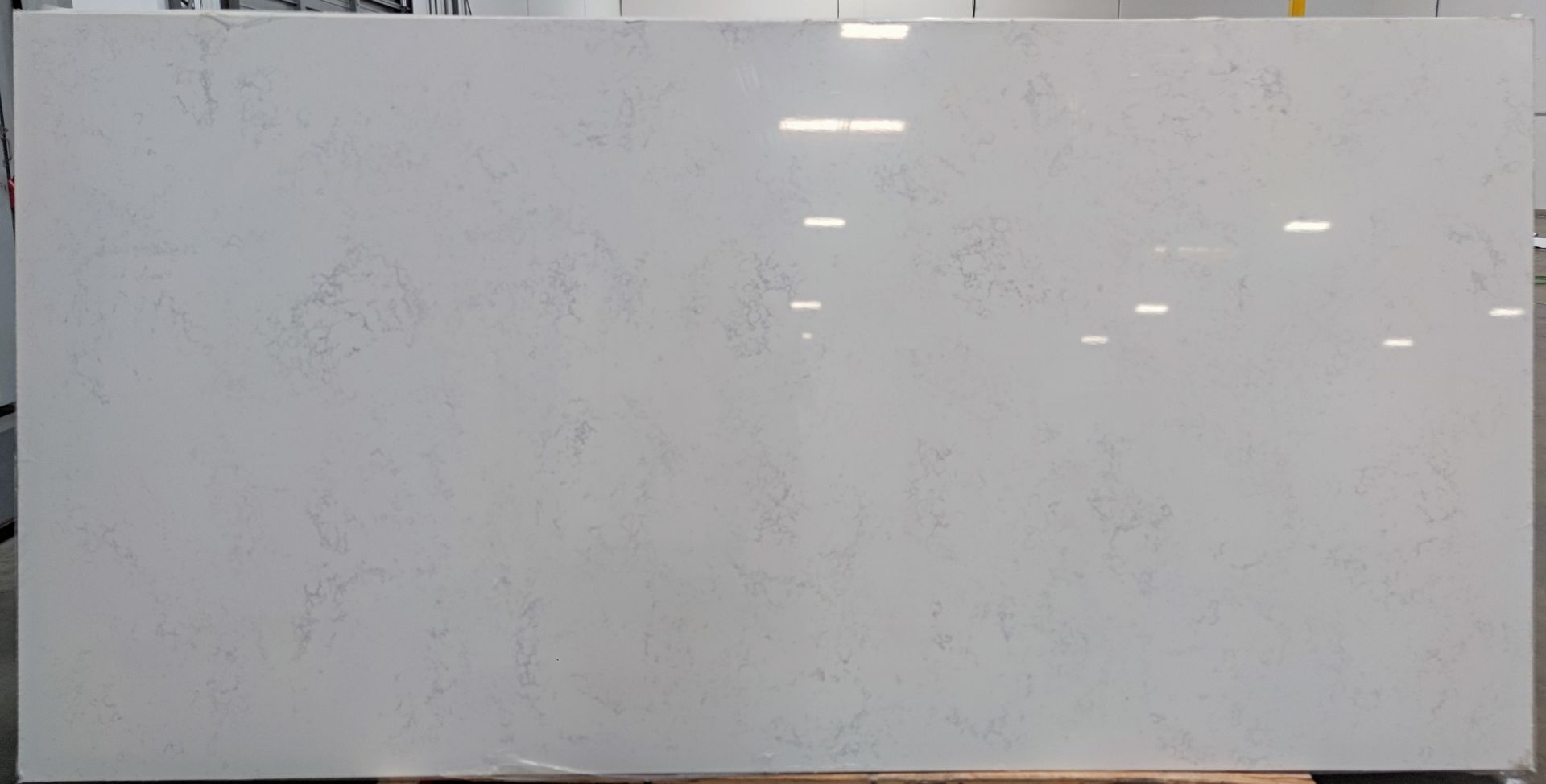 A large white granite slab is sitting on top of a wooden table.