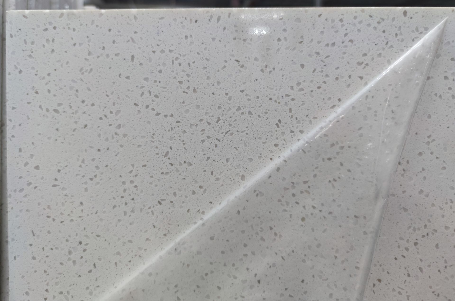 A close up of a piece of plastic covering a white tile.