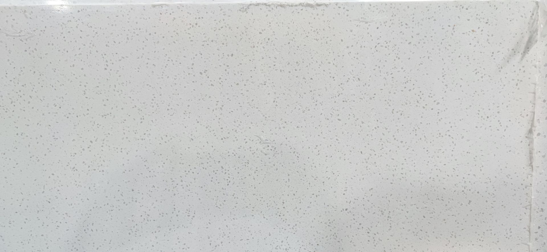 A close up of a white tile with small dots on it.