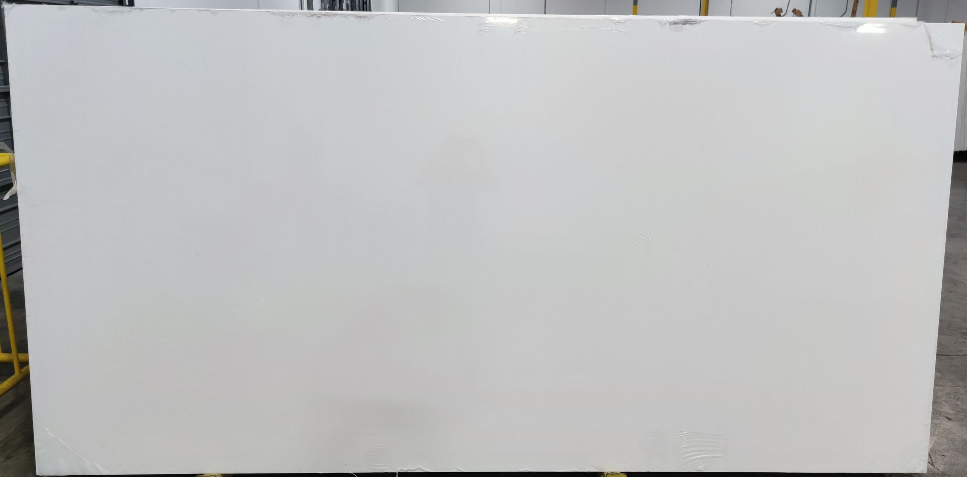 A large white slab of marble is sitting on top of a cement floor.