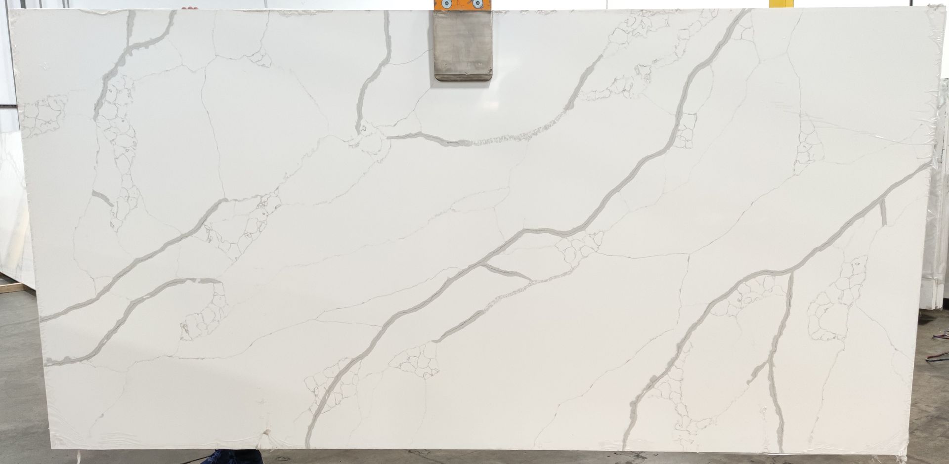 A white marble slab is sitting on top of a concrete floor.
