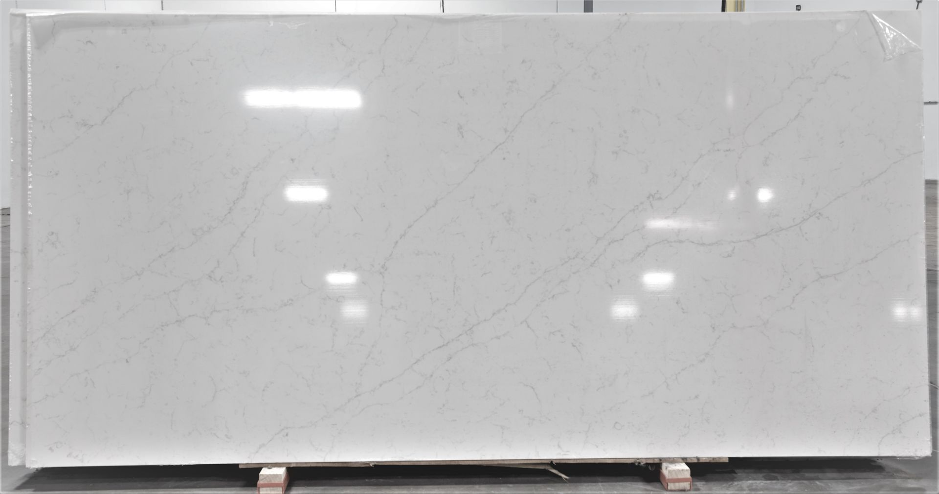 A large white granite slab is sitting on top of a wooden pallet.