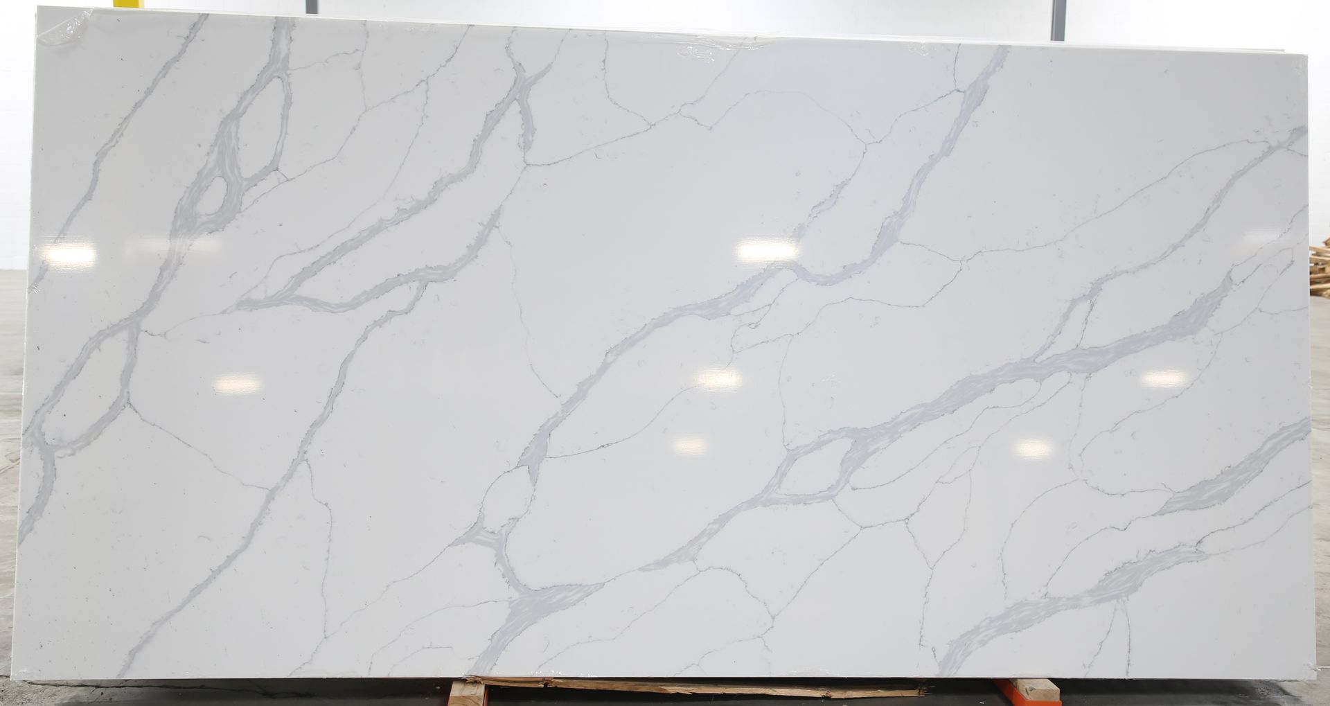 A large white marble slab is sitting on top of a wooden pallet.