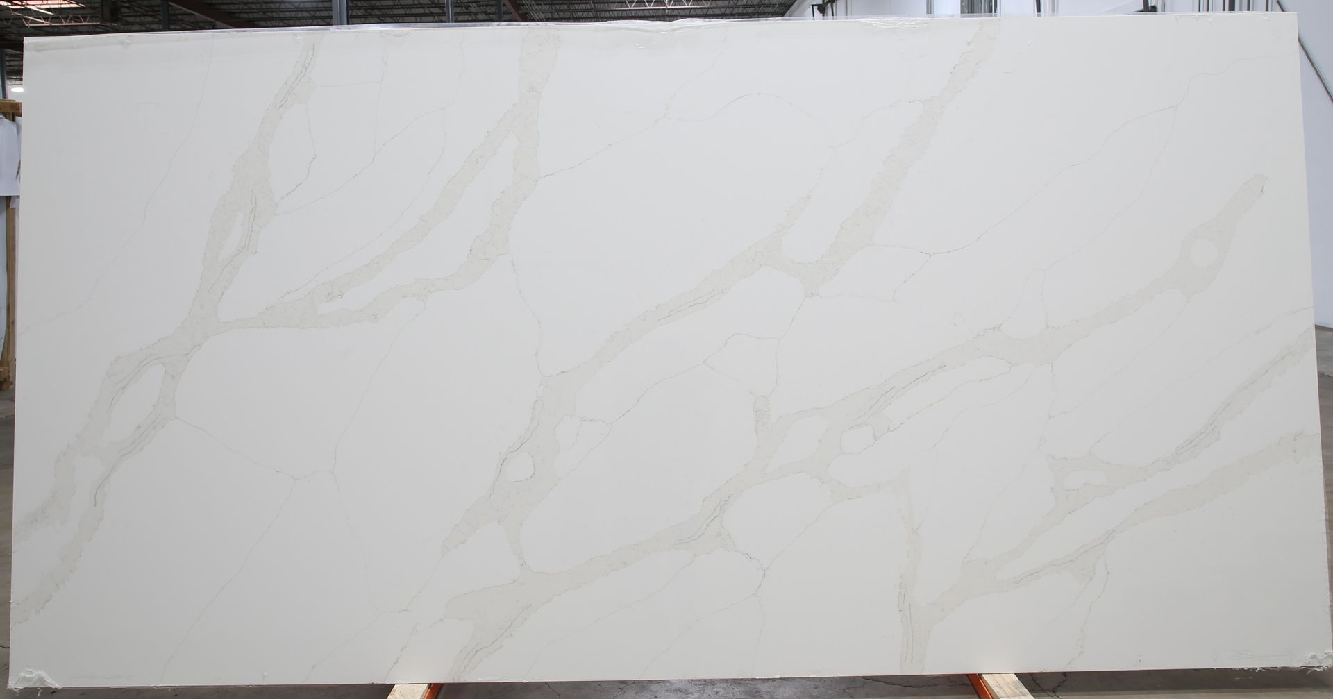 A large white slab of quartz is sitting on a wooden stand.