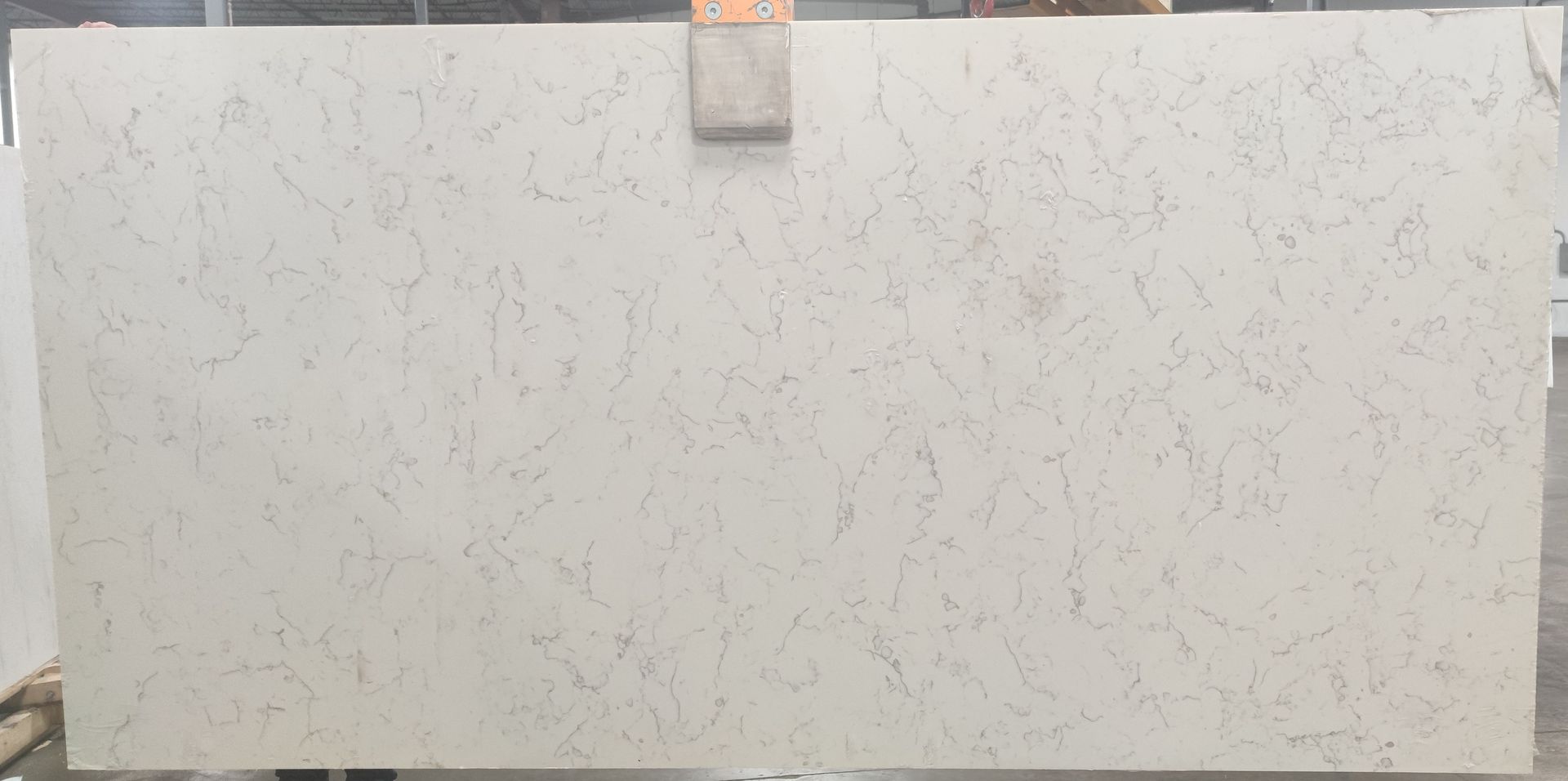 A large white granite slab is sitting on top of a wooden table.