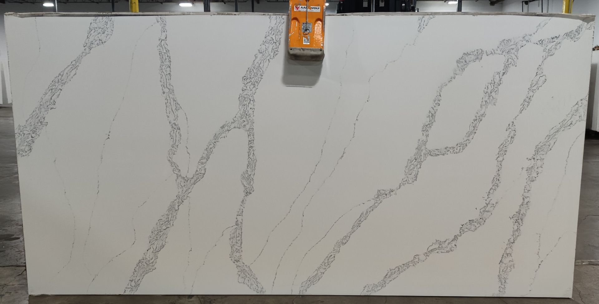 A white quartz counter top is sitting on top of a concrete floor.