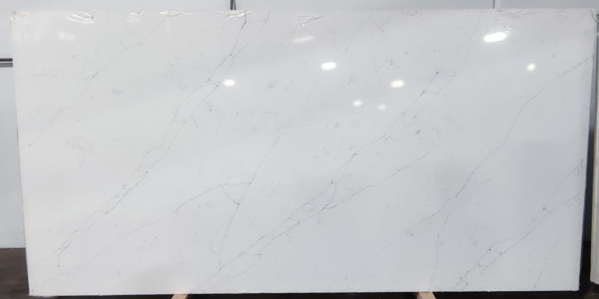 A large white marble slab is sitting on top of a wooden pallet.