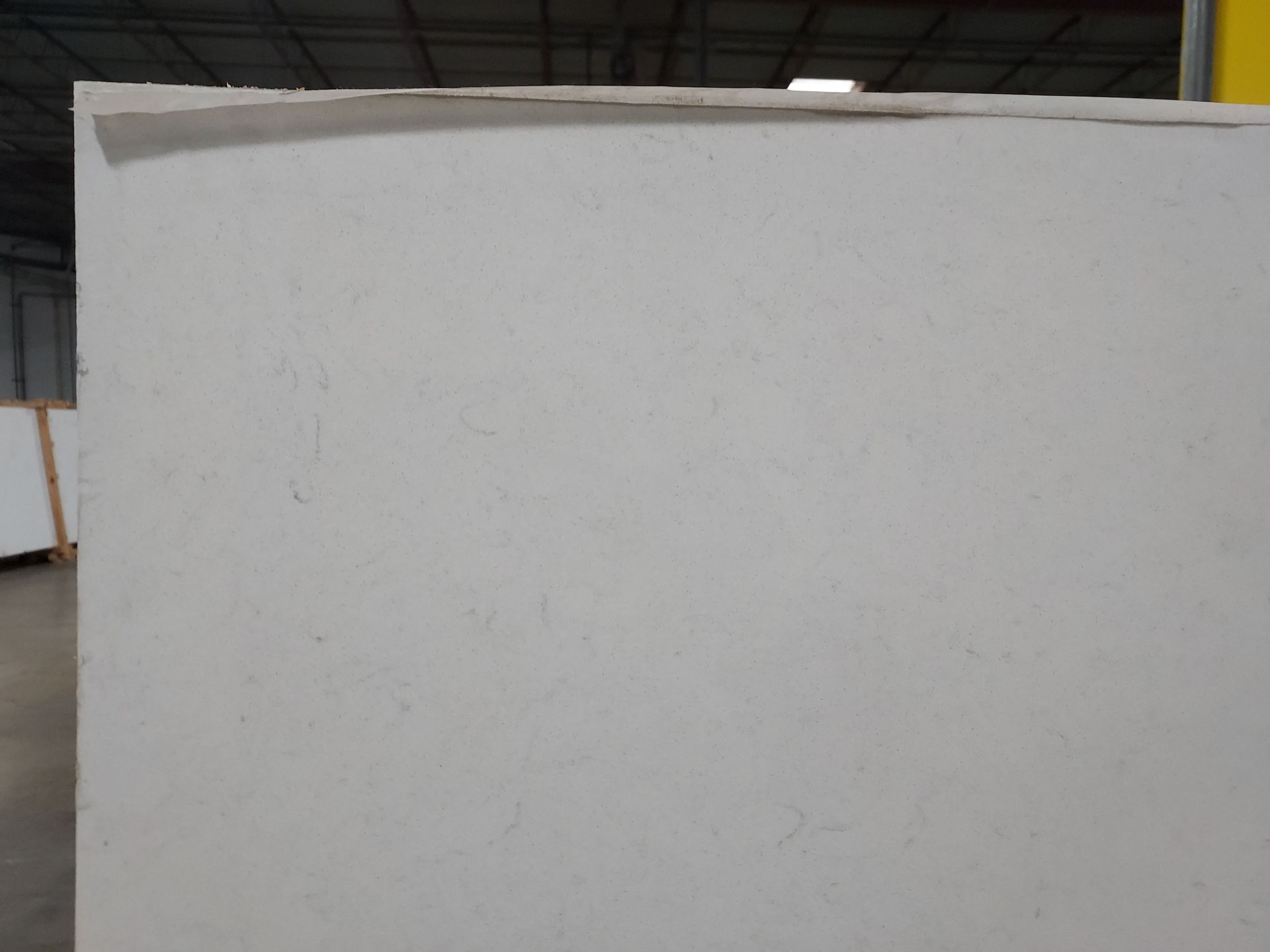 A piece of white paper is sitting on a table in a warehouse.