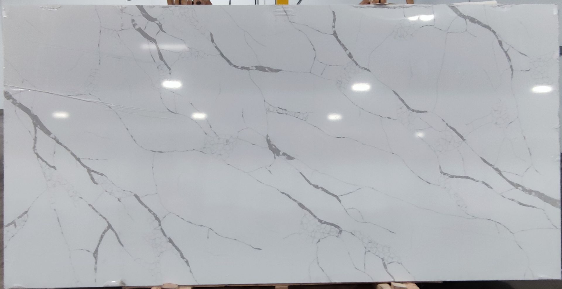 A person is holding a white marble slab in their hands.