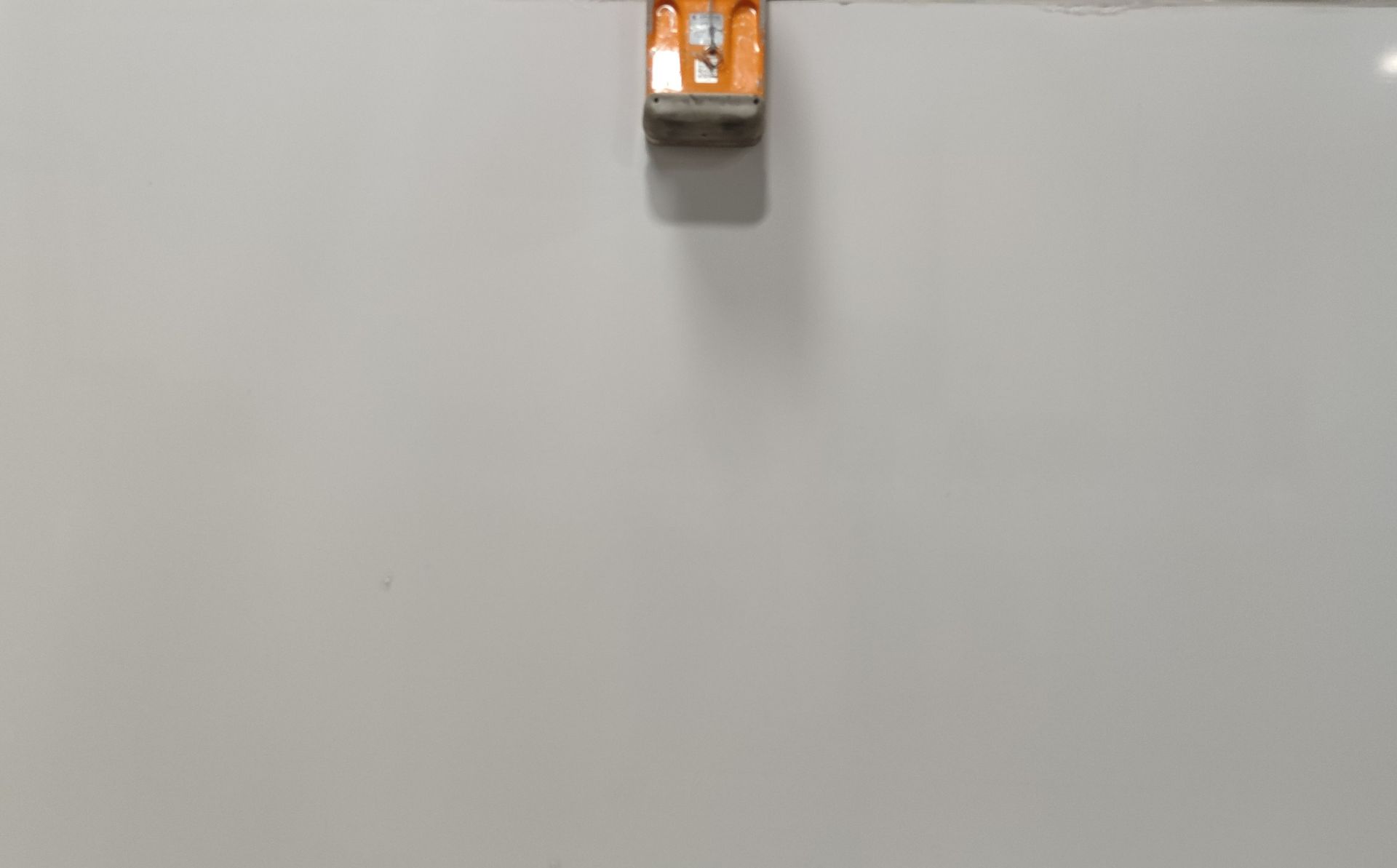 A white board with a pencil sharpener on it.