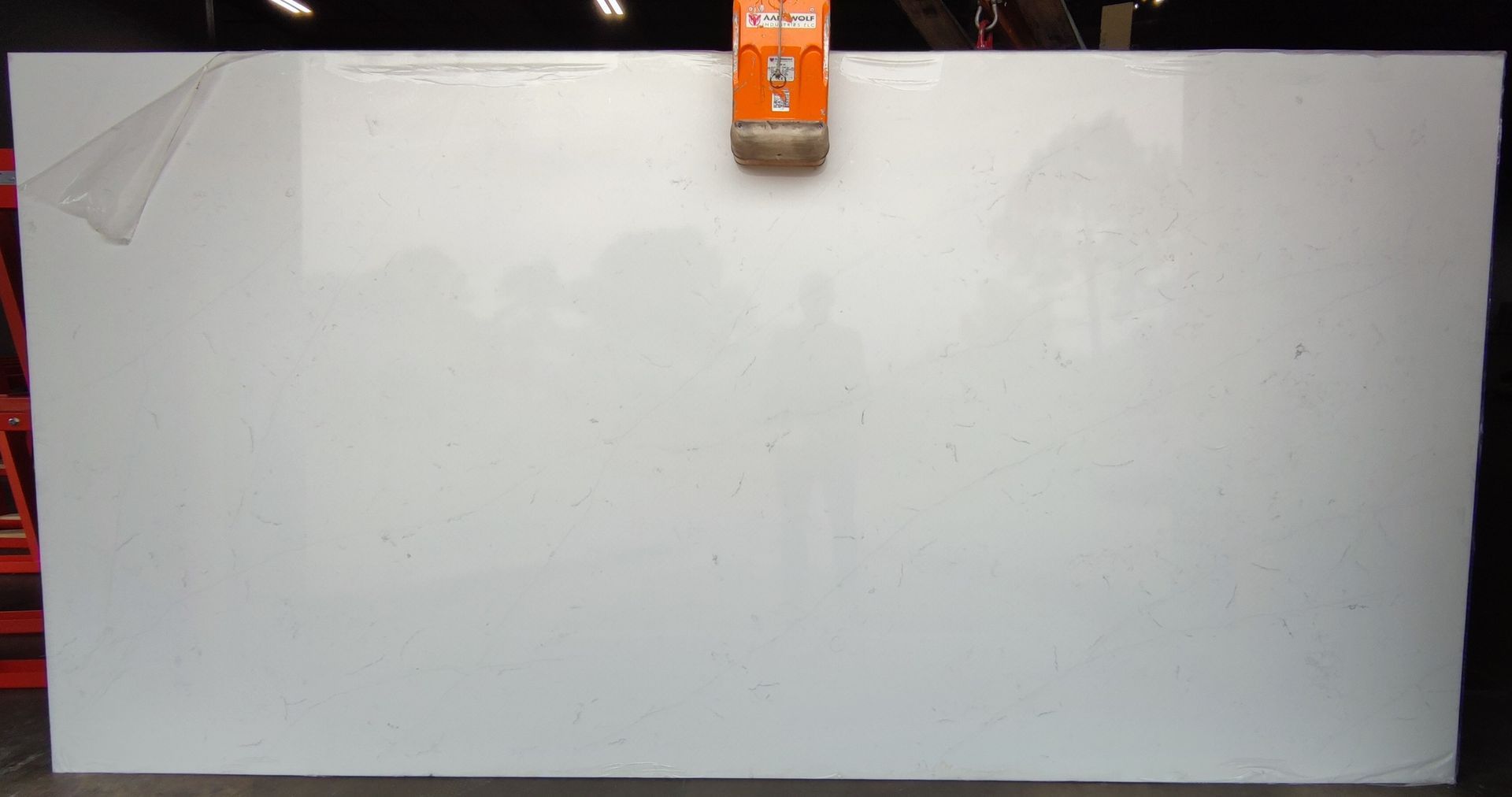 A large white slab of granite is sitting on a concrete floor.