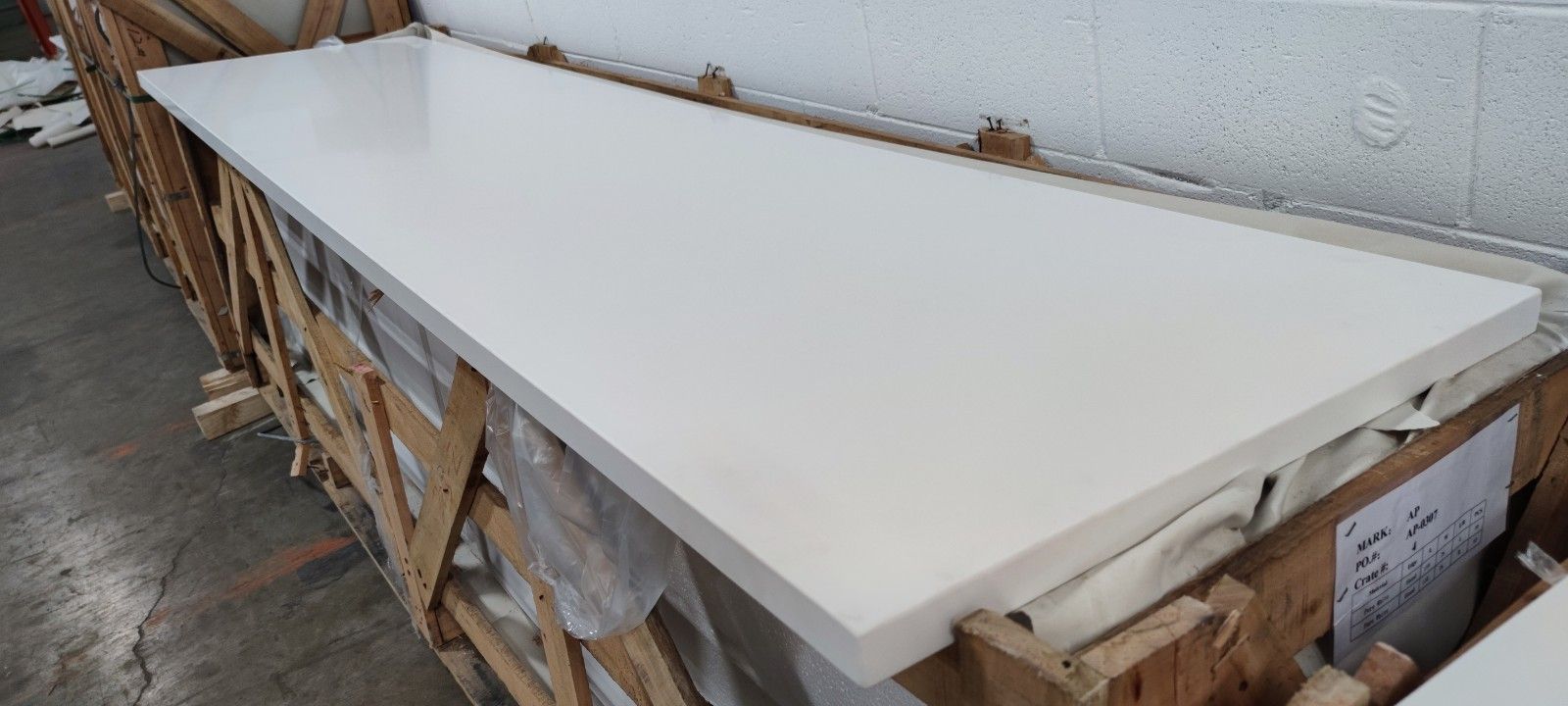 A long white counter top is sitting on top of a wooden crate.