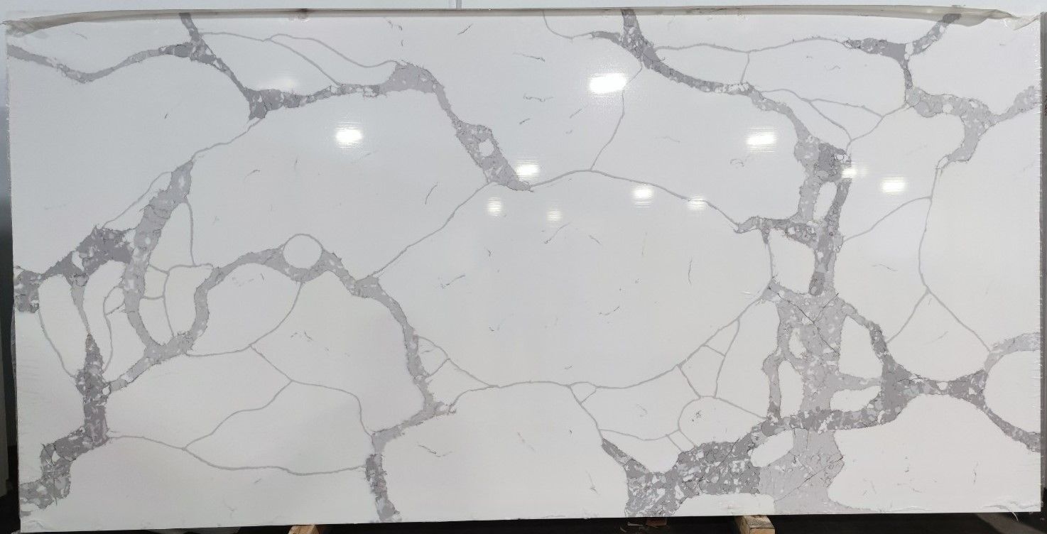 A large piece of white marble with a cracked pattern is sitting on top of a wooden table.
