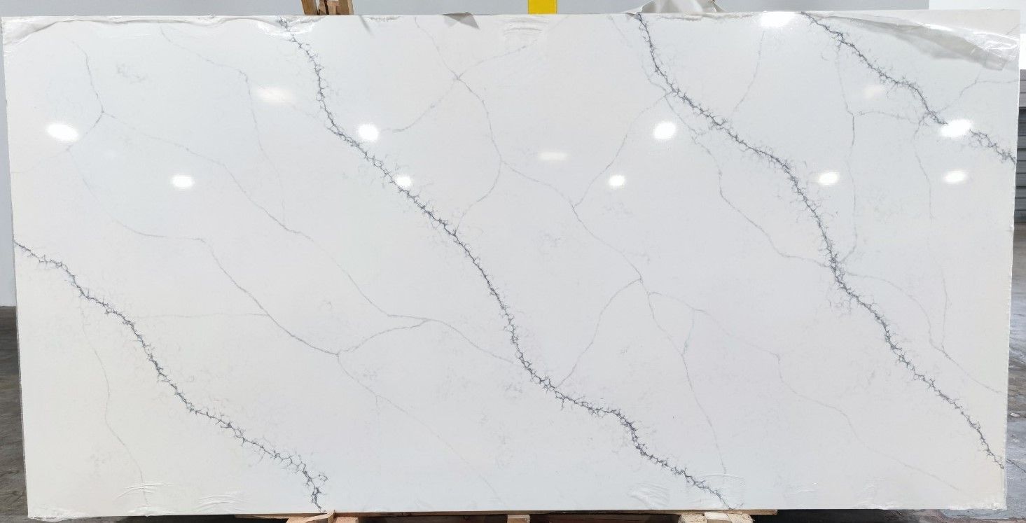 A white marble slab with black veins is sitting on a wooden stand.