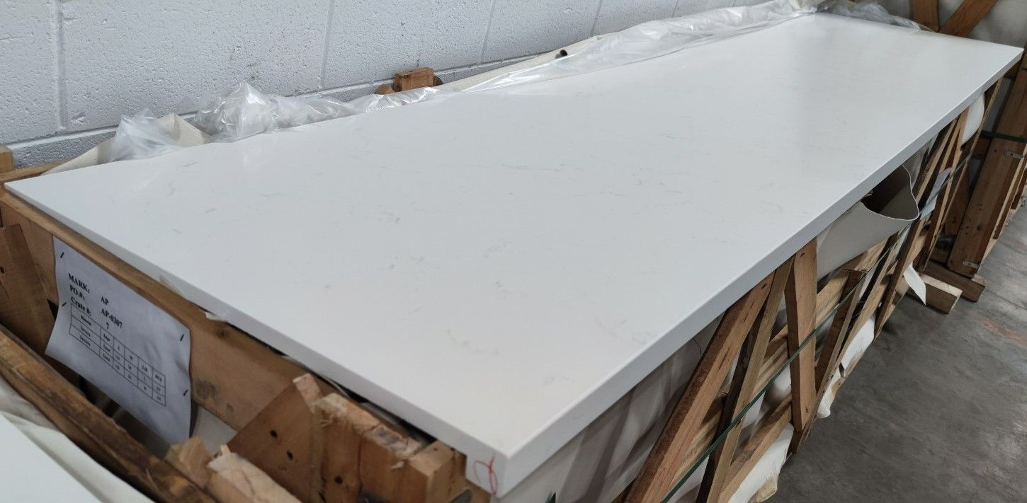 A white counter top is sitting on top of a wooden crate.