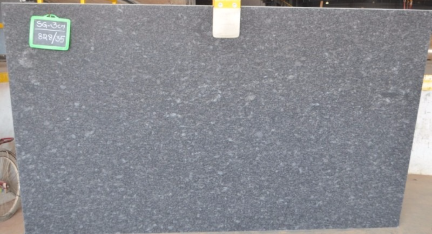 A black granite slab with a green tag on it is sitting on a table.
