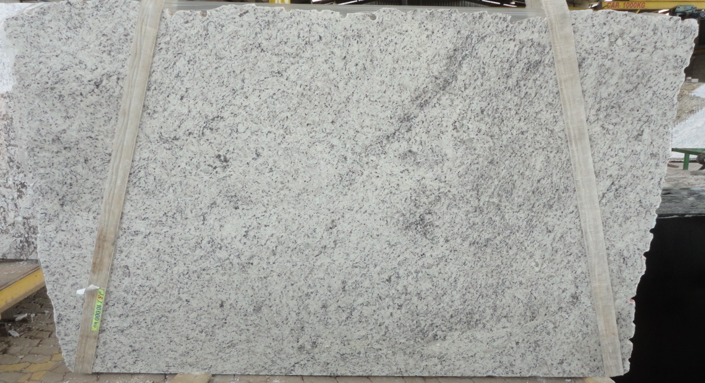 A white granite slab is sitting on top of a wooden table.