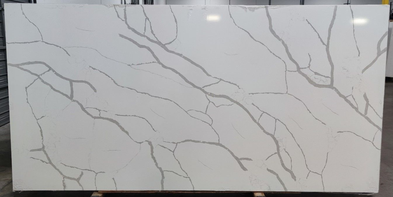 A large white granite slab with a marble texture is sitting on top of a wooden table.