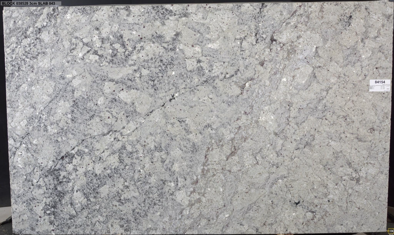A white granite slab is sitting on a black surface.