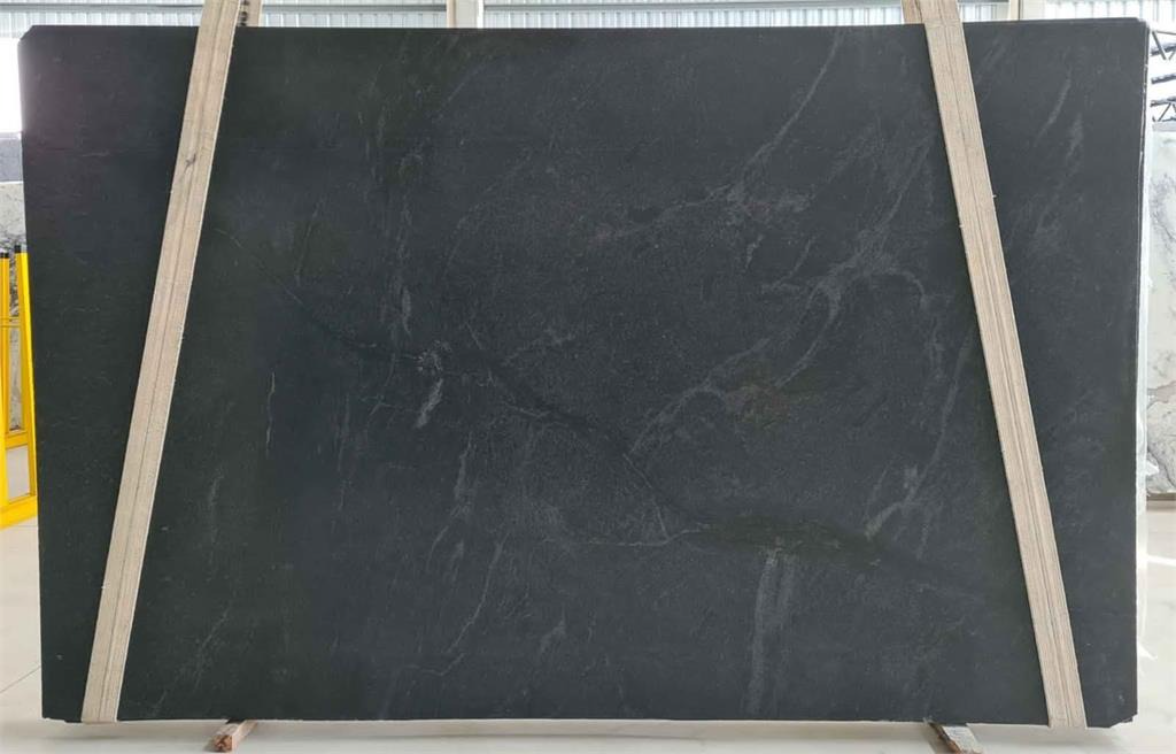 A large black slab of marble is sitting on a wooden stand.