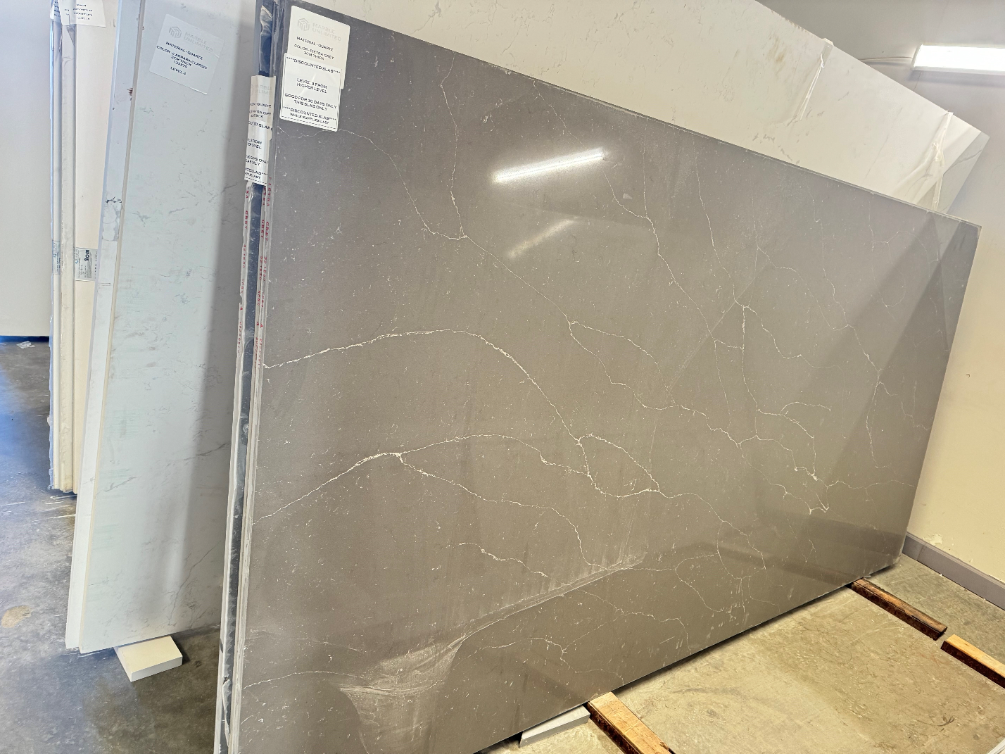 A large slab of granite is sitting on top of a wooden pallet in a warehouse.