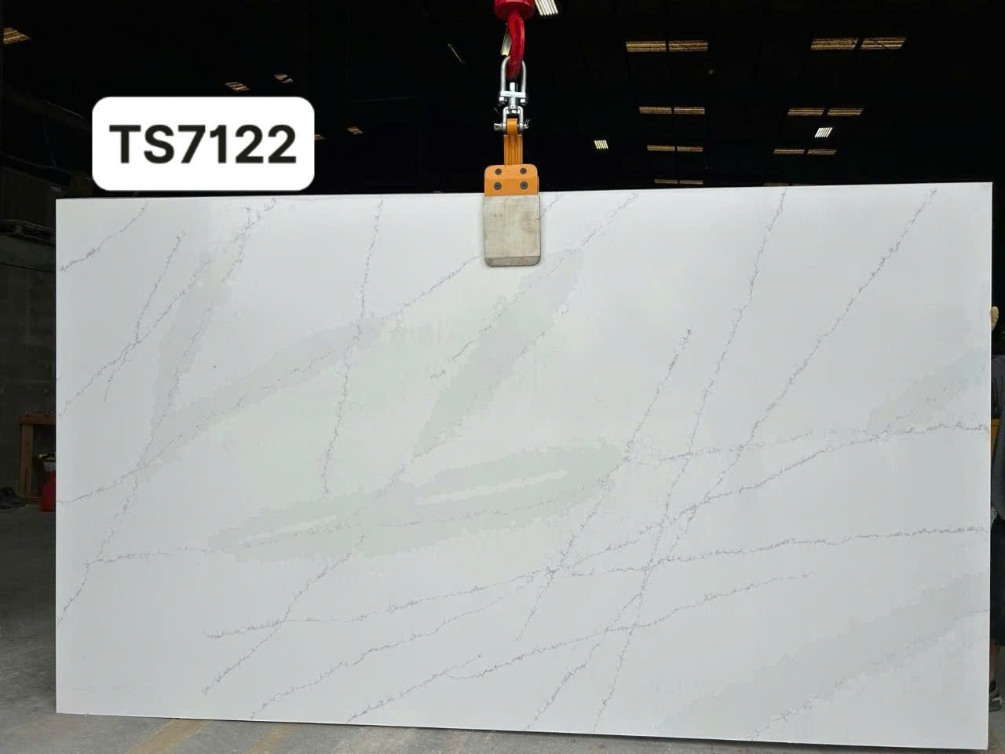 A large white slab of marble is being lifted by a crane.