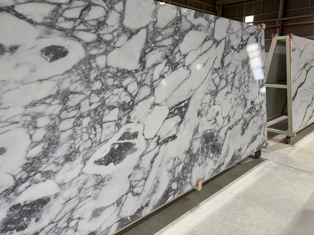 A marble slab is sitting on a cart in a warehouse.
