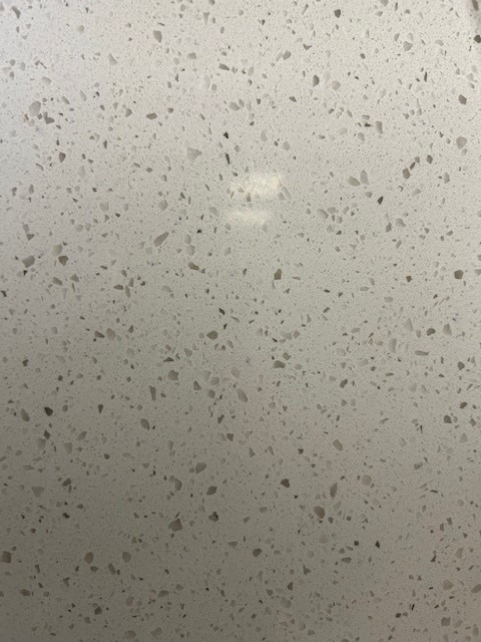 A close up of a white surface with small dots on it.