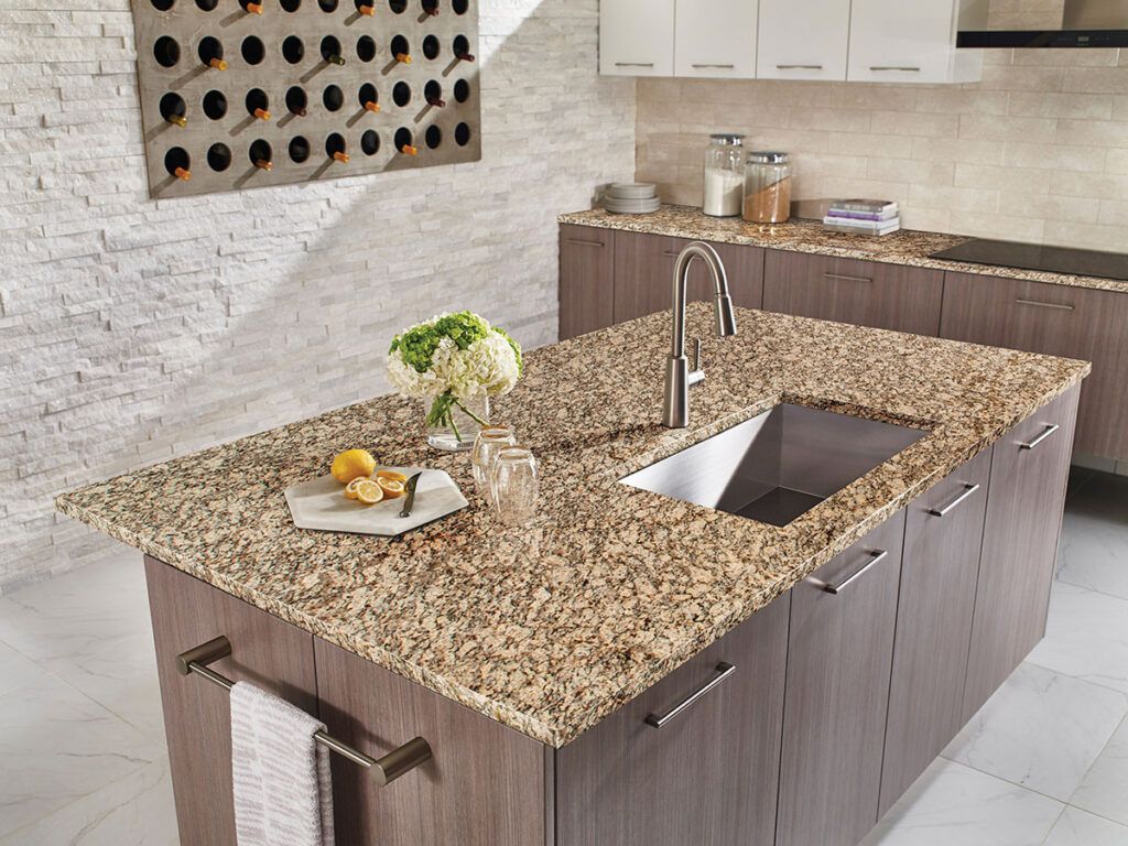 A kitchen with granite counter tops and a stainless steel sink.