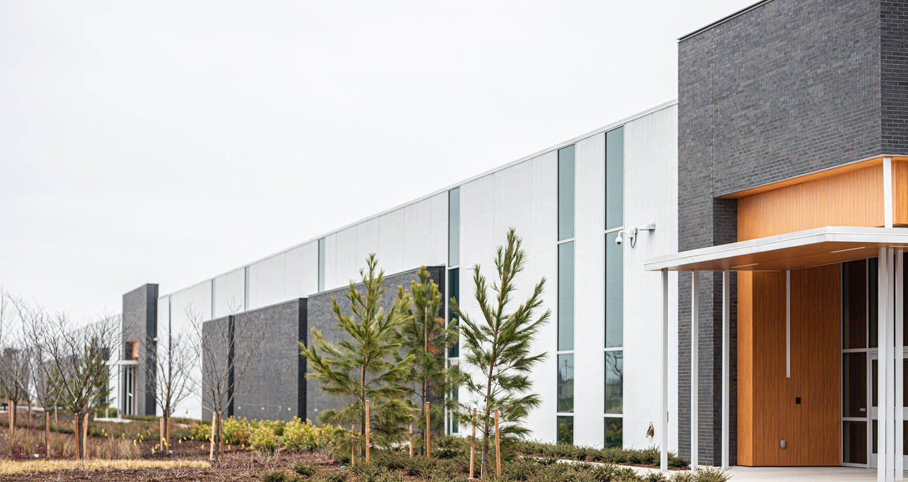 A large building with a lot of windows and trees in front of it.