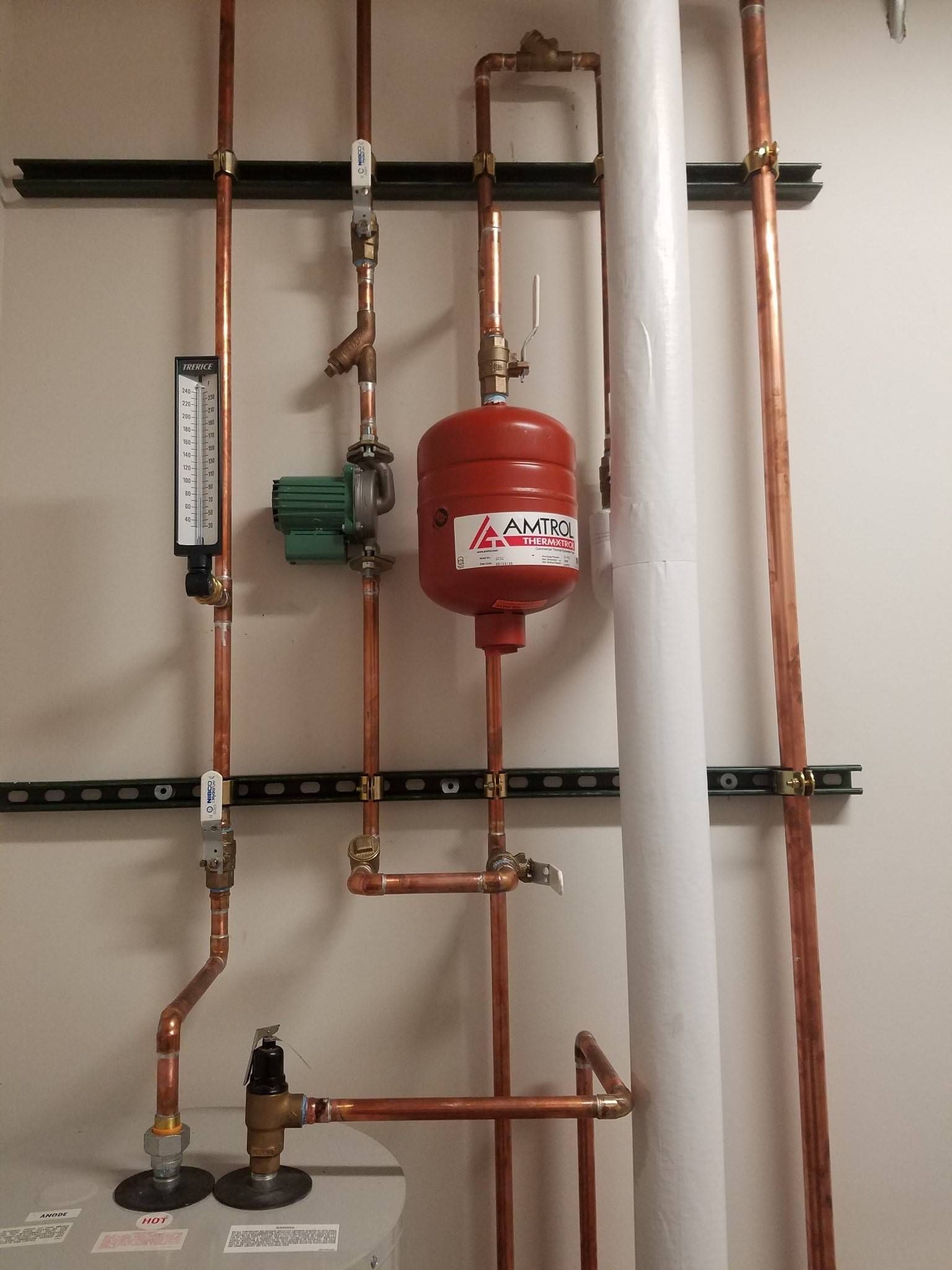 A water heater is connected to a copper pipe system.