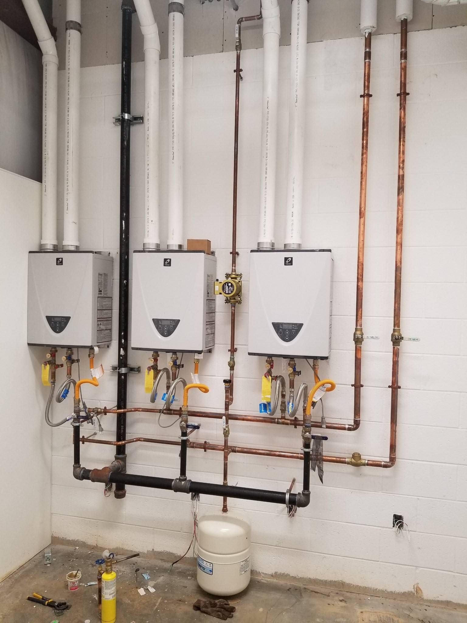 A room with a lot of pipes and boxes on the wall