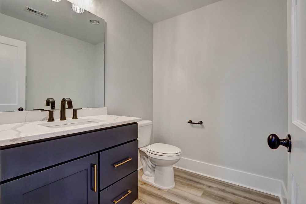 A bathroom with a sink , toilet and mirror.