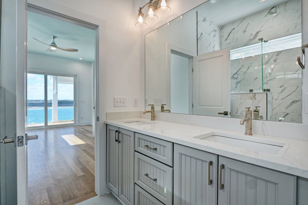 A bathroom with two sinks and a large mirror.