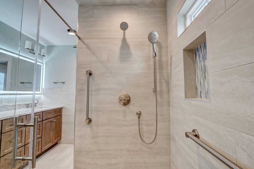 A bathroom with a walk in shower and two sinks.