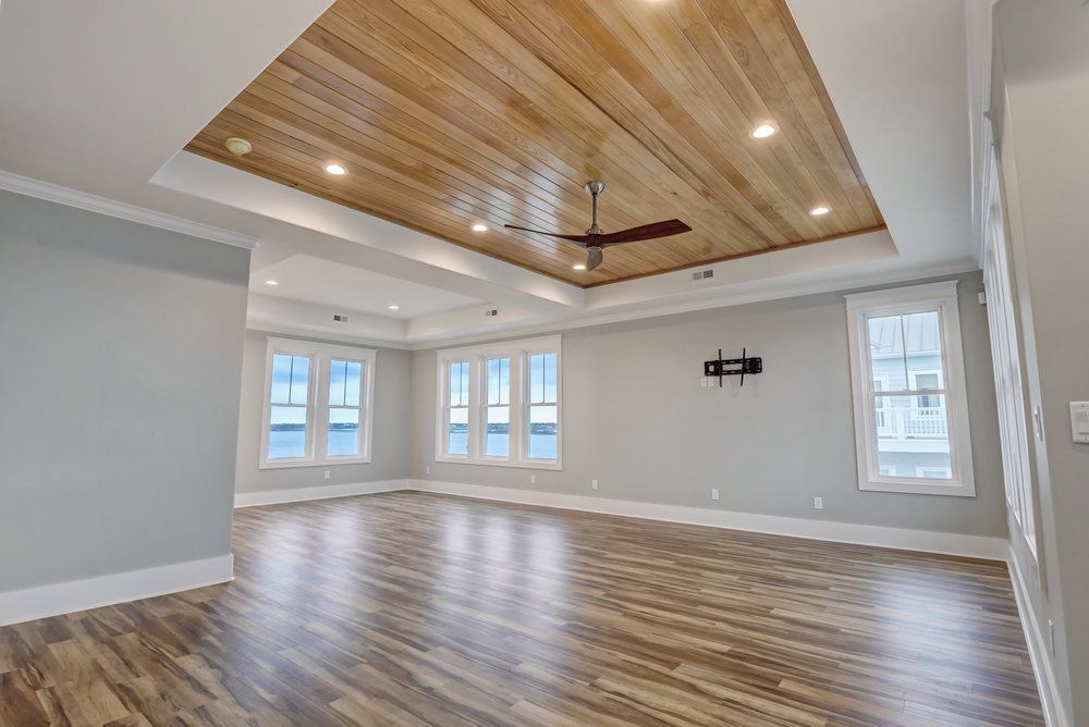 An empty living room with hardwood floors and a ceiling fan.