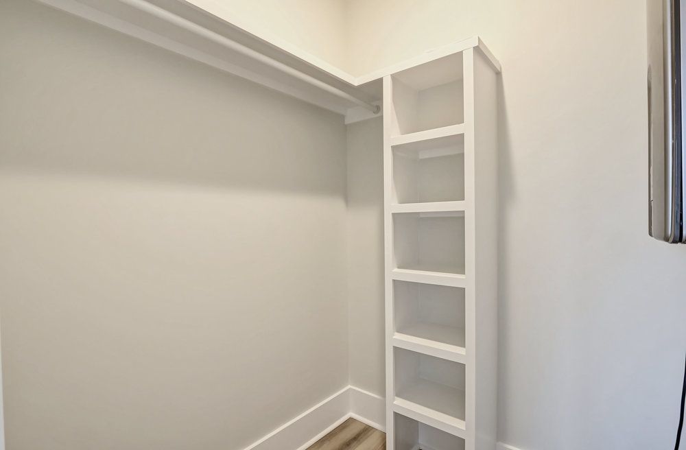 A walk in closet with a ladder and shelves.