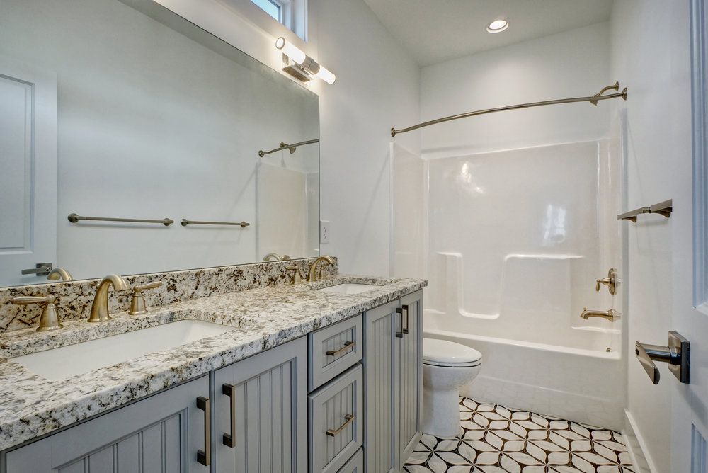 A bathroom with two sinks , a toilet , and a bathtub.