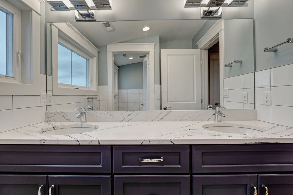 A bathroom with two sinks and a large mirror.