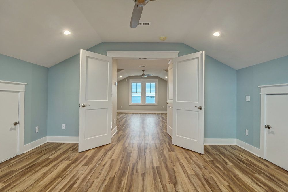 A large empty room with hardwood floors and blue walls.