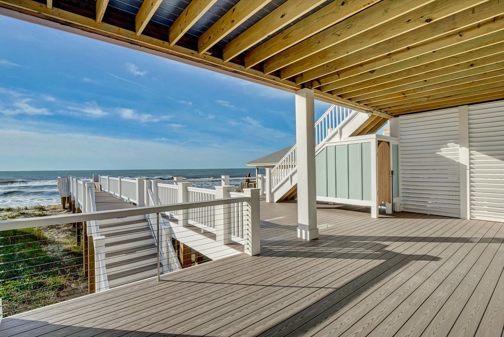There is a large deck with a view of the ocean.