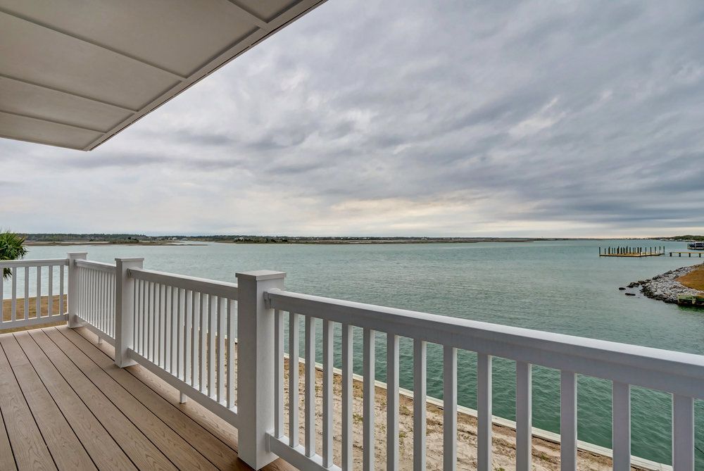 A balcony overlooking a body of water with a white railing