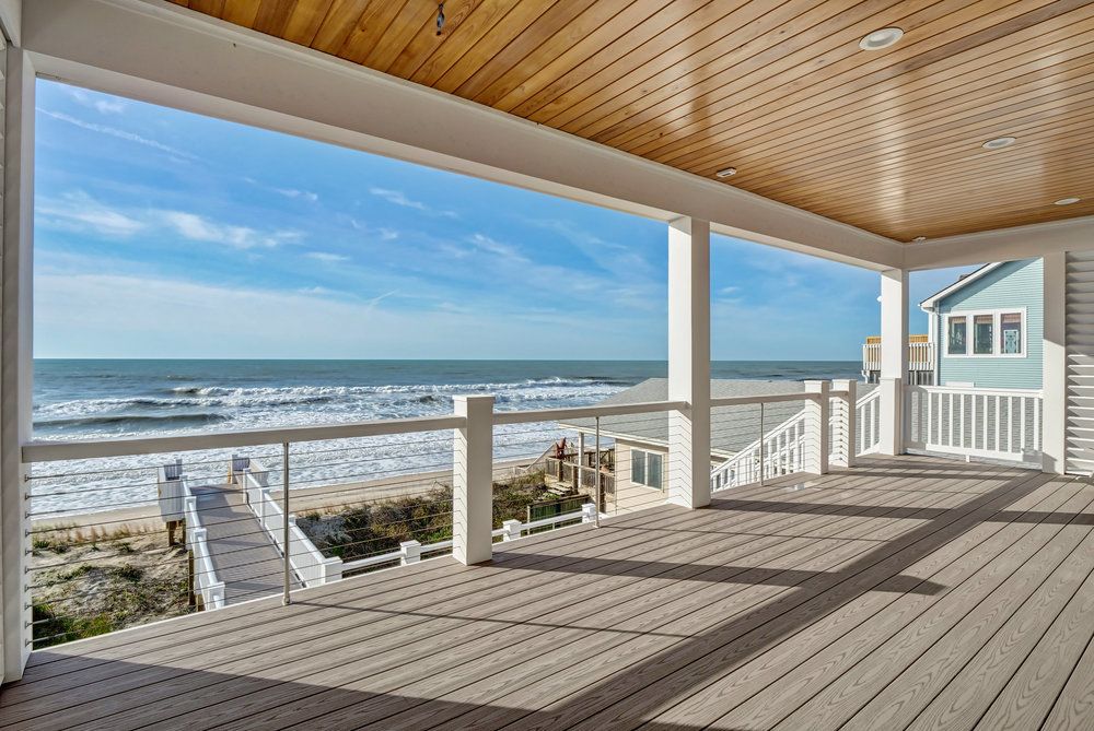 There is a large deck with a view of the ocean.