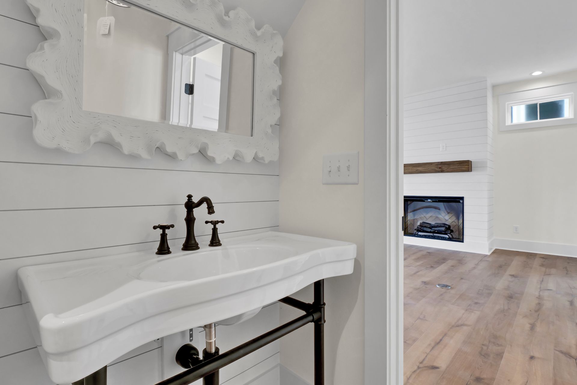 A bathroom with a sink , mirror and fireplace.