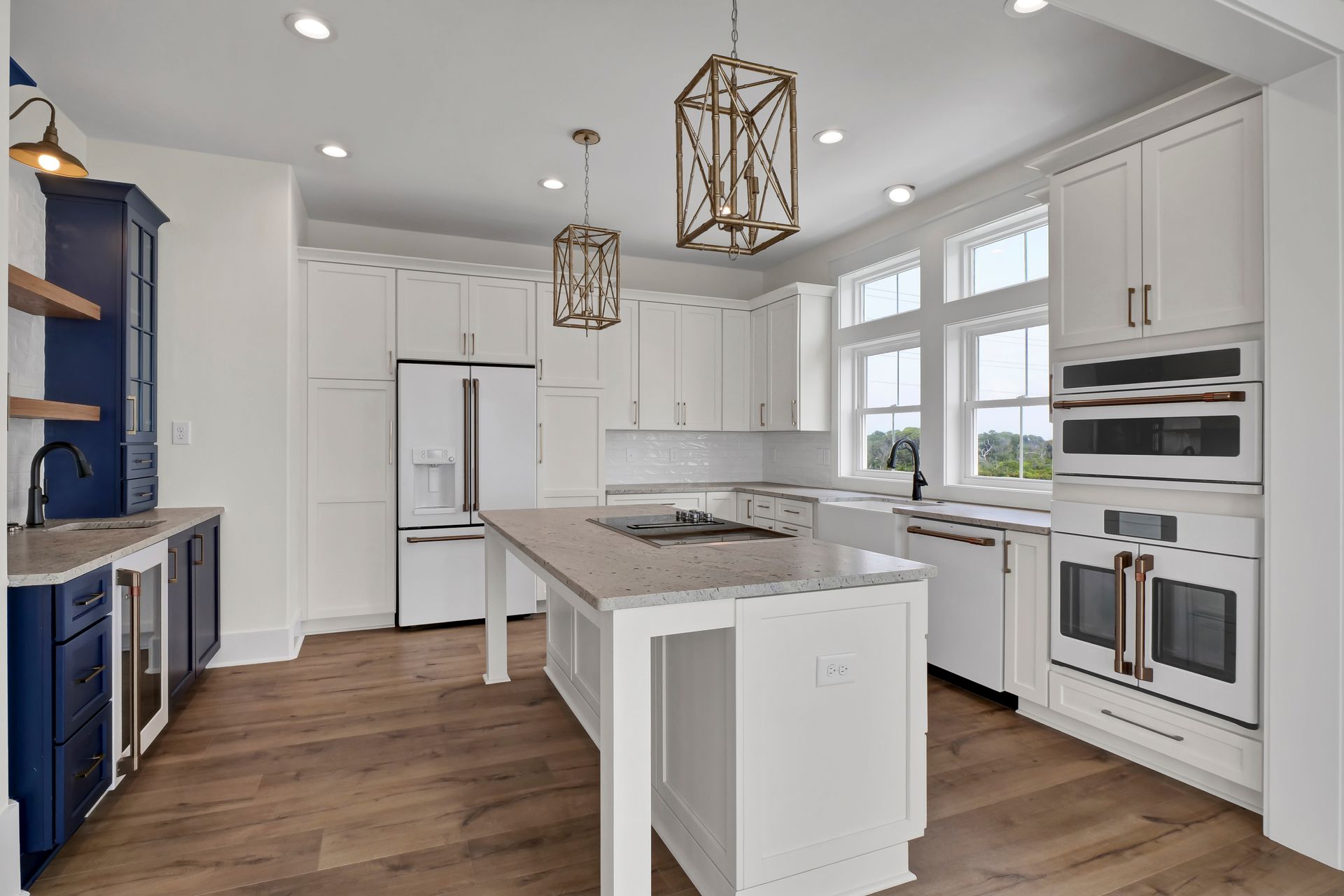 A kitchen with white cabinets and a large island in the middle.