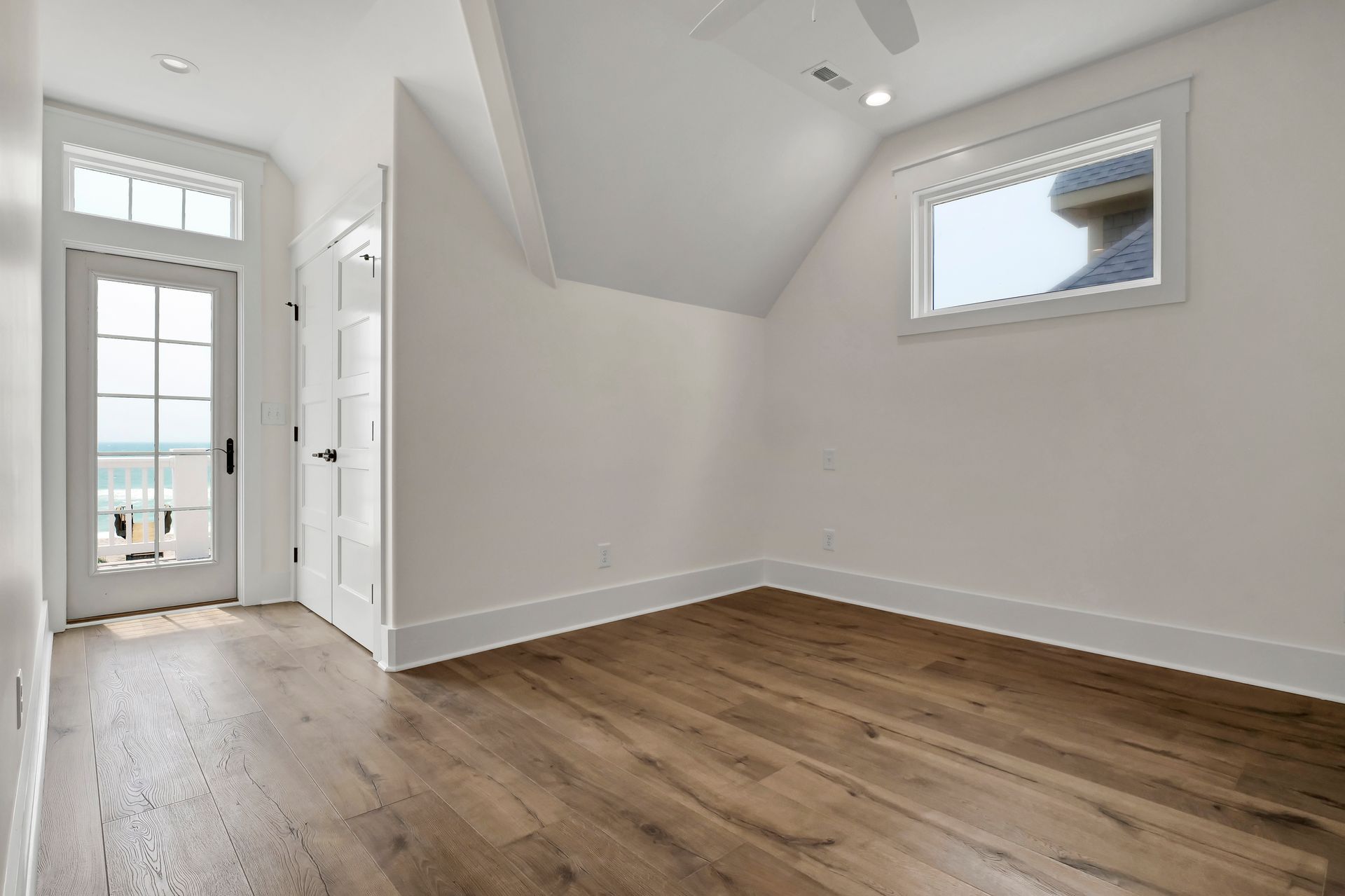 An empty room with hardwood floors and a window.