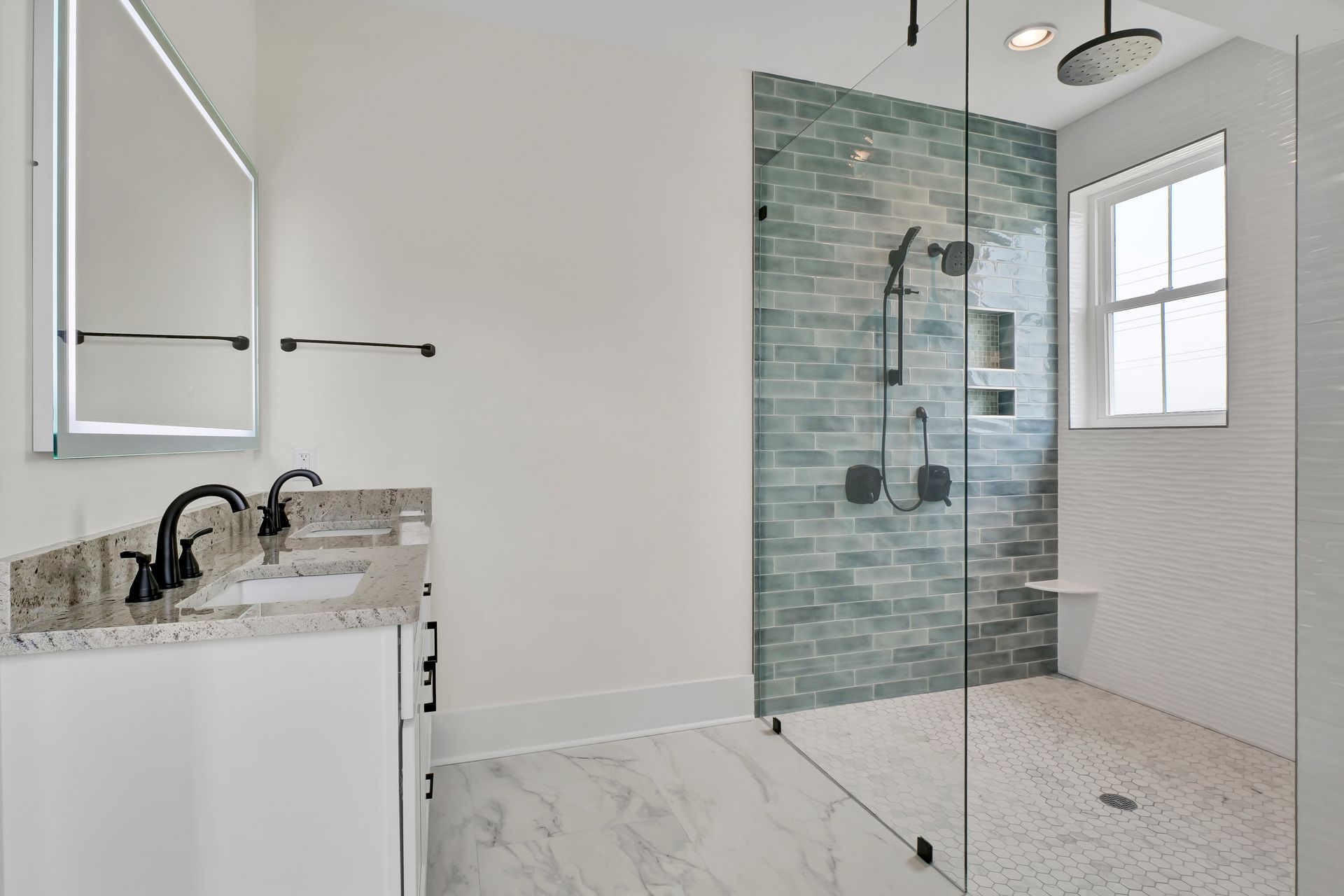 A bathroom with a walk in shower , sink and mirror.