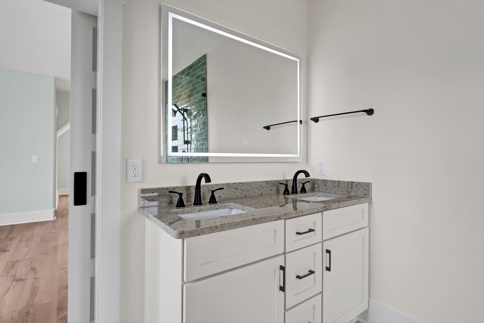 A bathroom with two sinks and a large mirror.