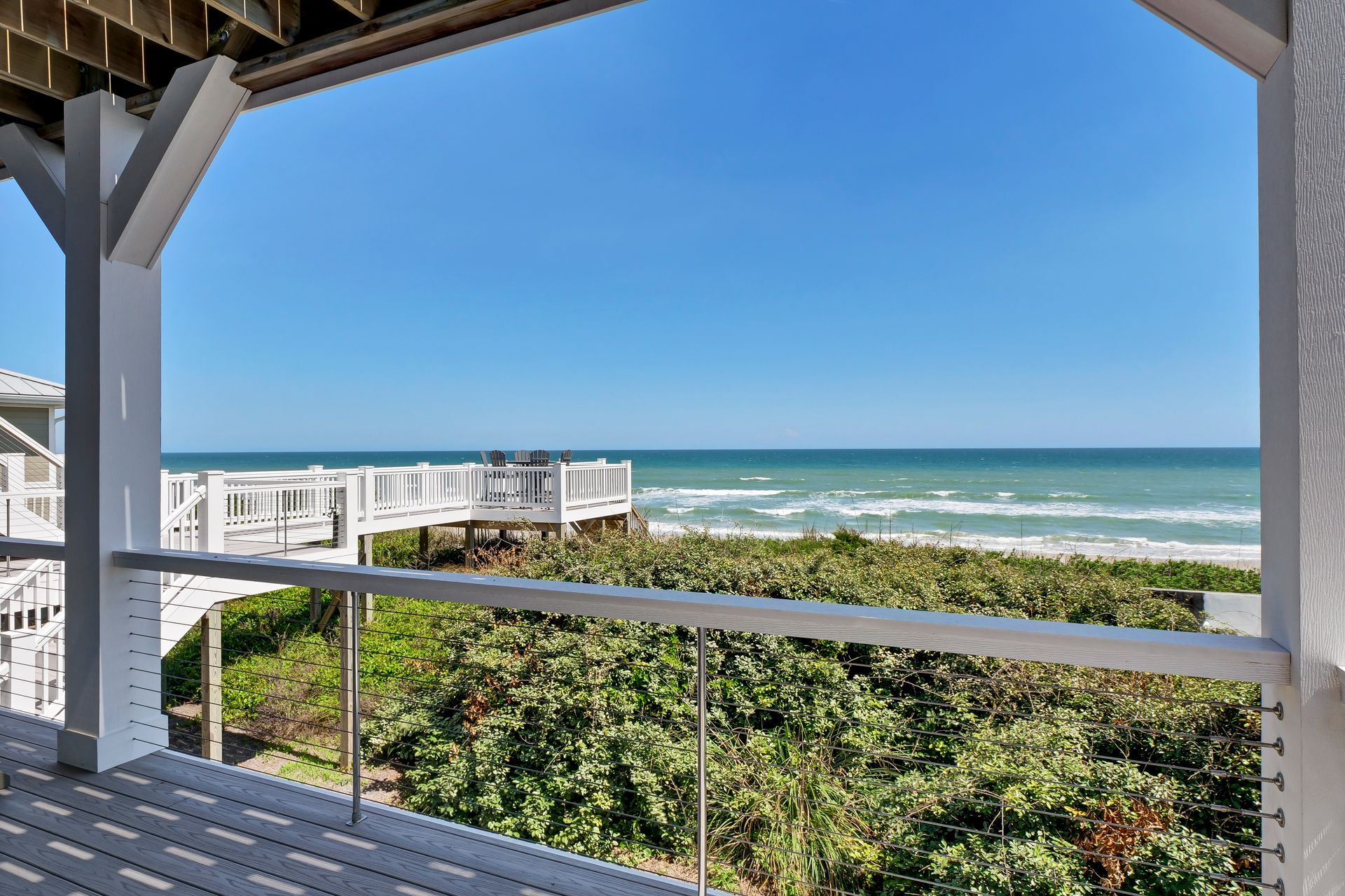 A balcony with a view of the ocean and trees
