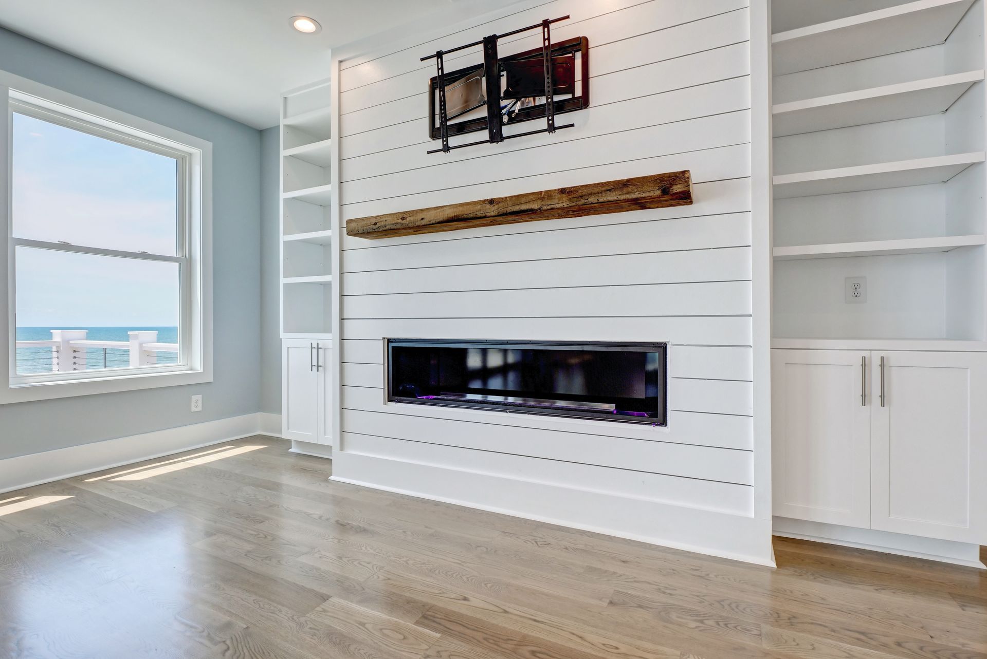 A living room with a fireplace and a television mounted on the wall.